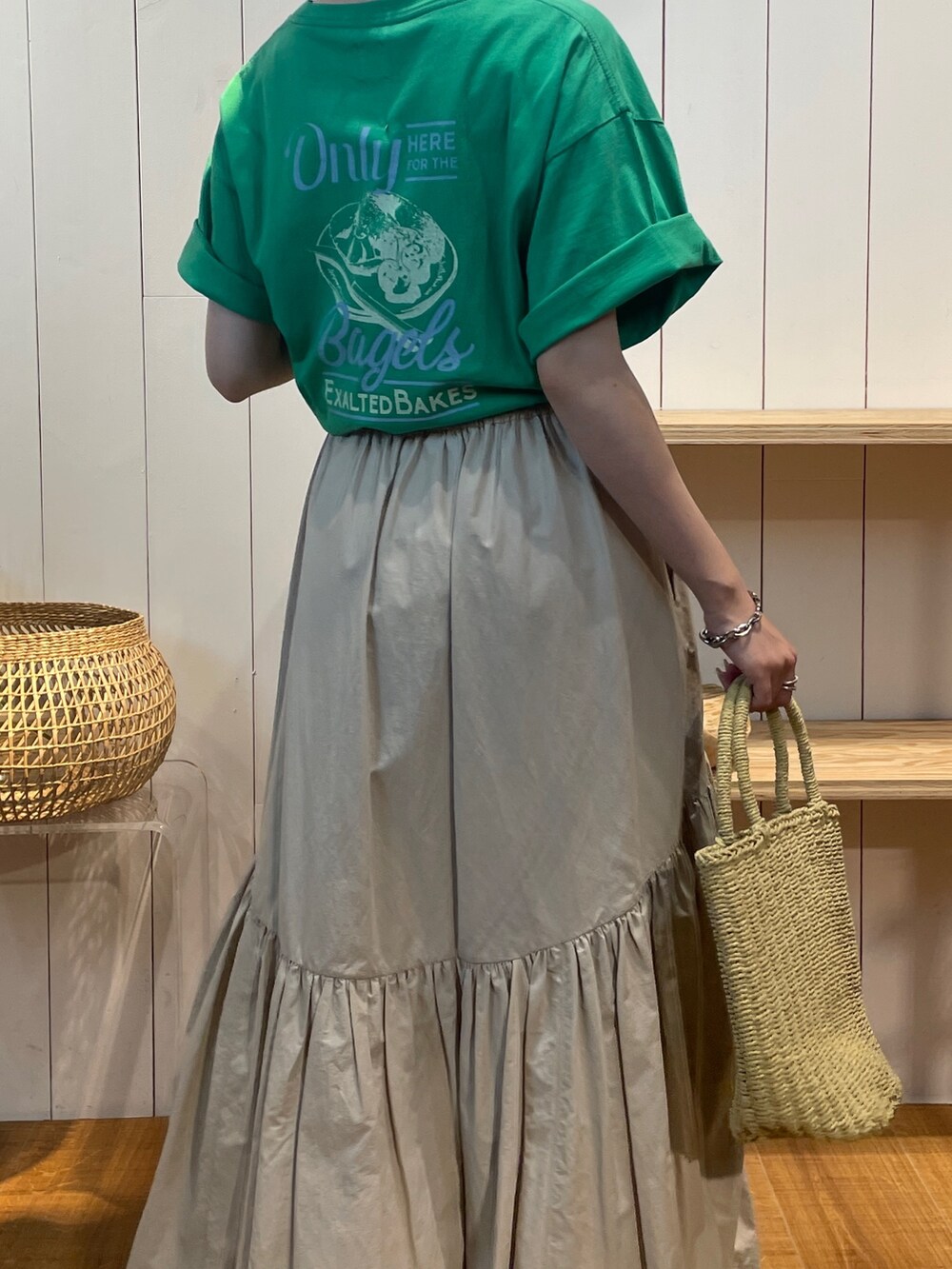 グリーン系のTシャツ/カットソー、ホワイト系のスカート、ベージュ系のかごバッグを着用したレディースの夏コーディネートの5枚目の写真