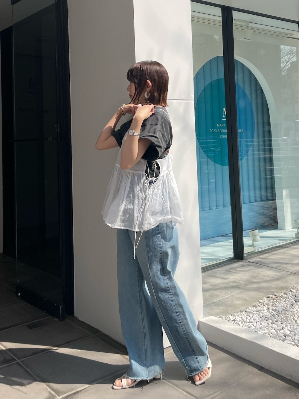 ブルー系のデニムパンツ、グレー系のTシャツ/カットソー、ホワイト系のショルダーバッグを着用したレディースの春コーディネートの4枚目の写真