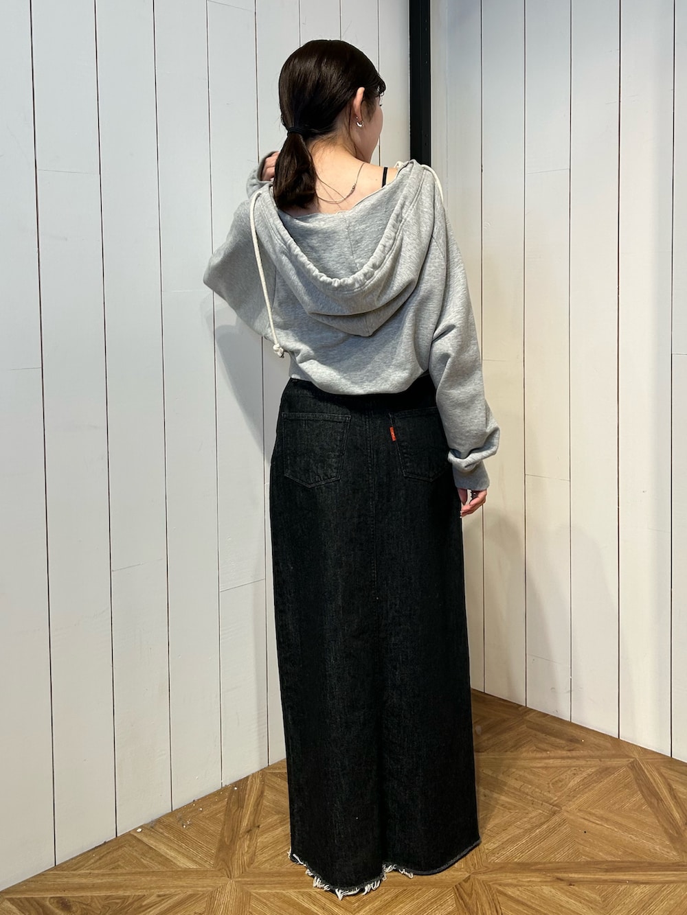 ブラック系のパンプス、ブラック系のスカート、グレー系のパーカーを着用したレディースの春コーディネートの5枚目の写真