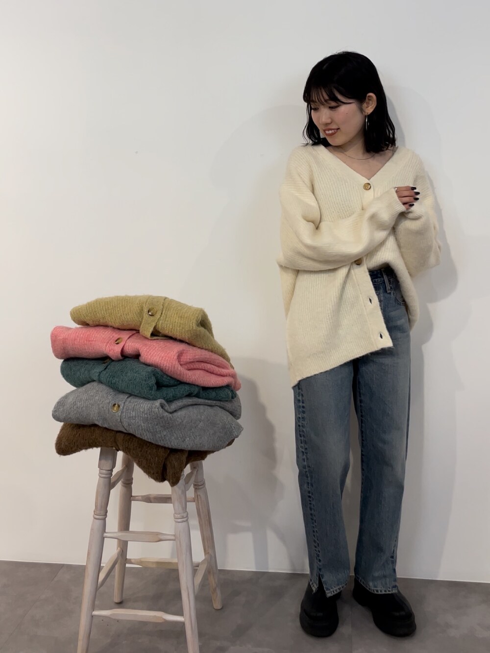ブルー系のデニムパンツ、ブラック系のブーツ、ホワイト系のカーディガン/ボレロを着用したレディースの冬コーディネートの7枚目の写真