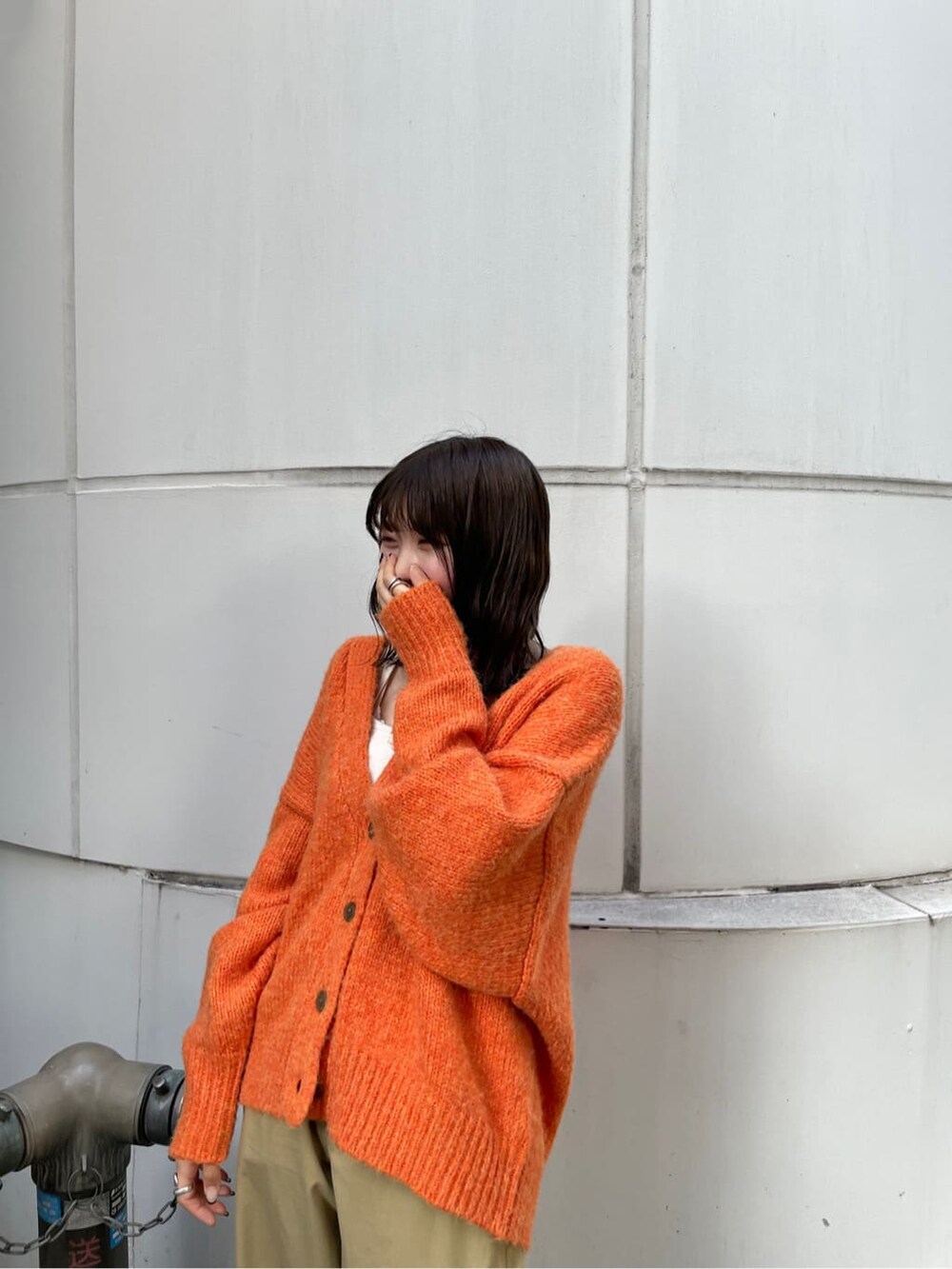 ベージュ系のチノパンツ、オレンジ系のカーディガン/ボレロを着用したレディースの夏コーディネートの6枚目の写真