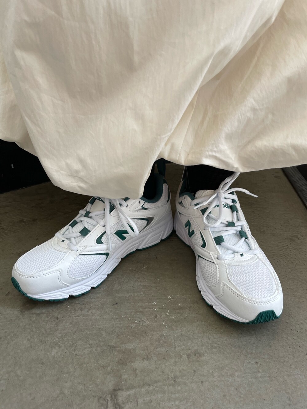 グレー系のスウェット、ホワイト系のスカート、グリーン系のスニーカーを着用したレディースの夏コーディネートの7枚目の写真