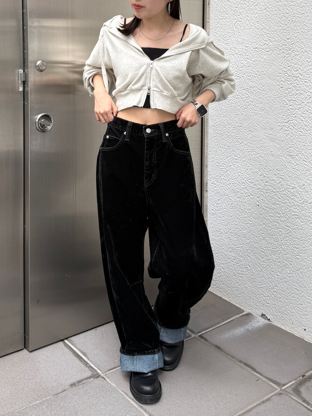 ホワイト系のパーカー、ブラック系のデニムパンツ、ベージュ系のキャップを着用したレディースの秋コーディネートの3枚目の写真