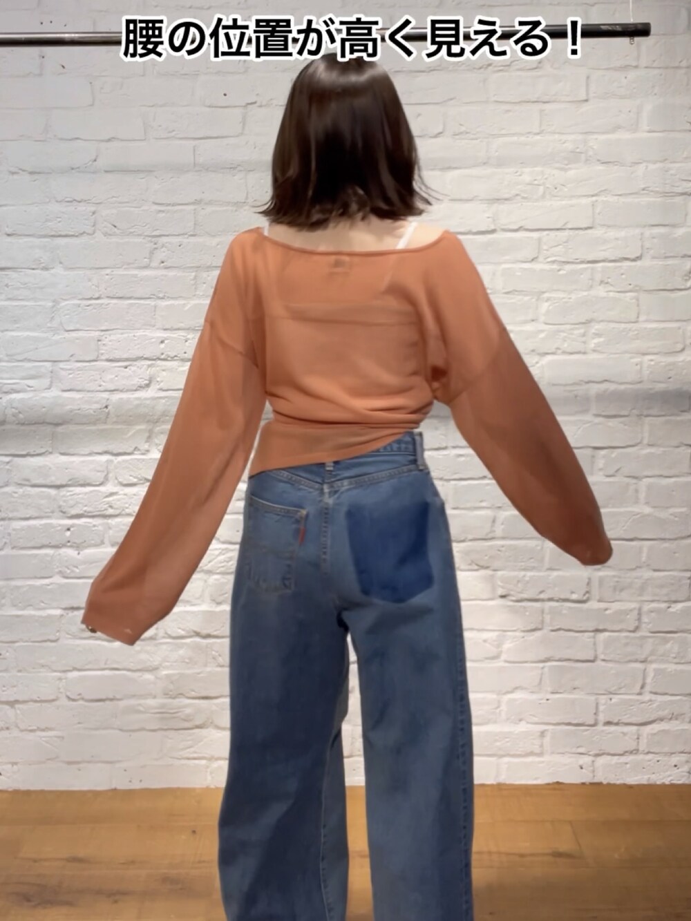 ブラック系のサンダル、オレンジ系のニット/セーター、ブルー系のデニムパンツを着用したレディースの春コーディネートの5枚目の写真