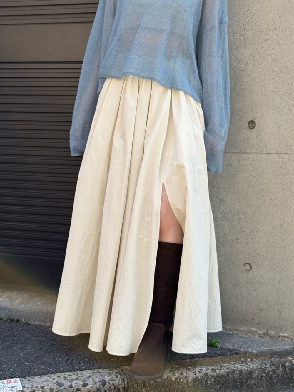 ホワイト系のスカート、ブラウン系のブーツ、ブルー系のニット/セーターを着用したレディースの秋コーディネートの5枚目の写真