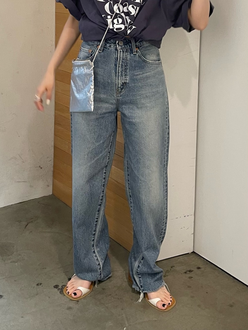 ホワイト系のサンダル、ブルー系のデニムパンツ、シルバー系のショルダーバッグを着用したレディースの春コーディネートの8枚目の写真