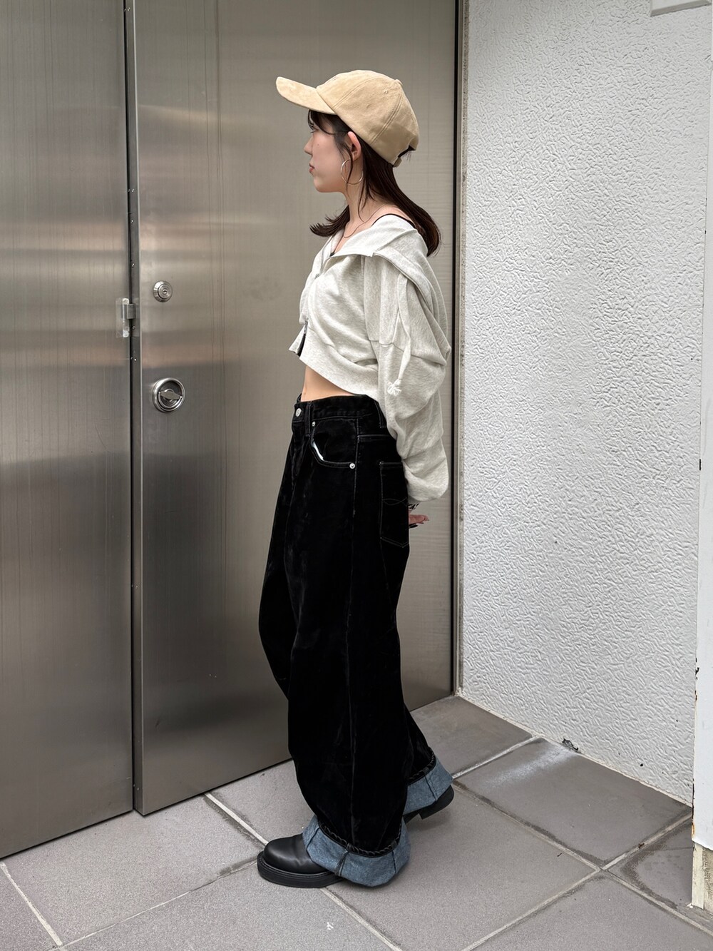 ホワイト系のパーカー、ブラック系のデニムパンツ、ベージュ系のキャップを着用したレディースの秋コーディネートの4枚目の写真