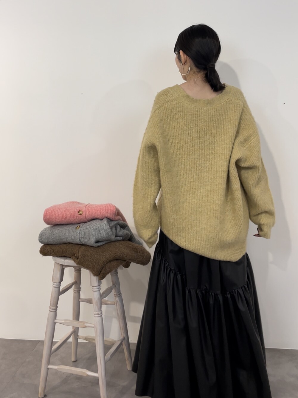 ブラック系のスカート、ブラック系のブーツ、イエロー系のカーディガン/ボレロを着用したレディースの冬コーディネートの4枚目の写真