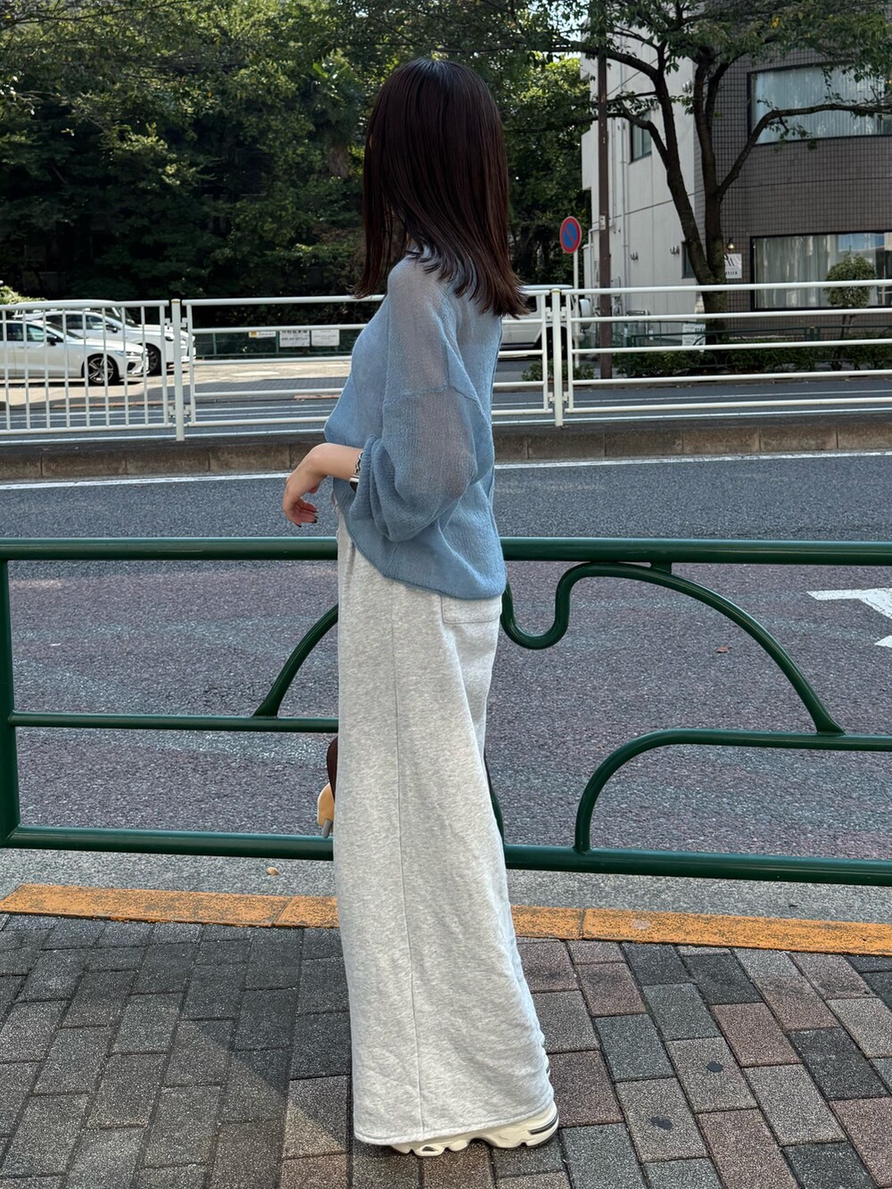 ブルー系のニット/セーター、ブラウン系のハンドバッグを着用したレディースの秋コーディネートの3枚目の写真