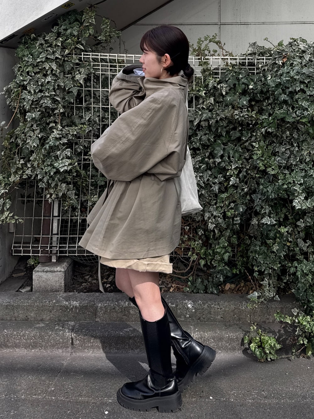 グリーン系のトレンチコート、ベージュ系のその他パンツを着用したレディースの冬コーディネートの5枚目の写真