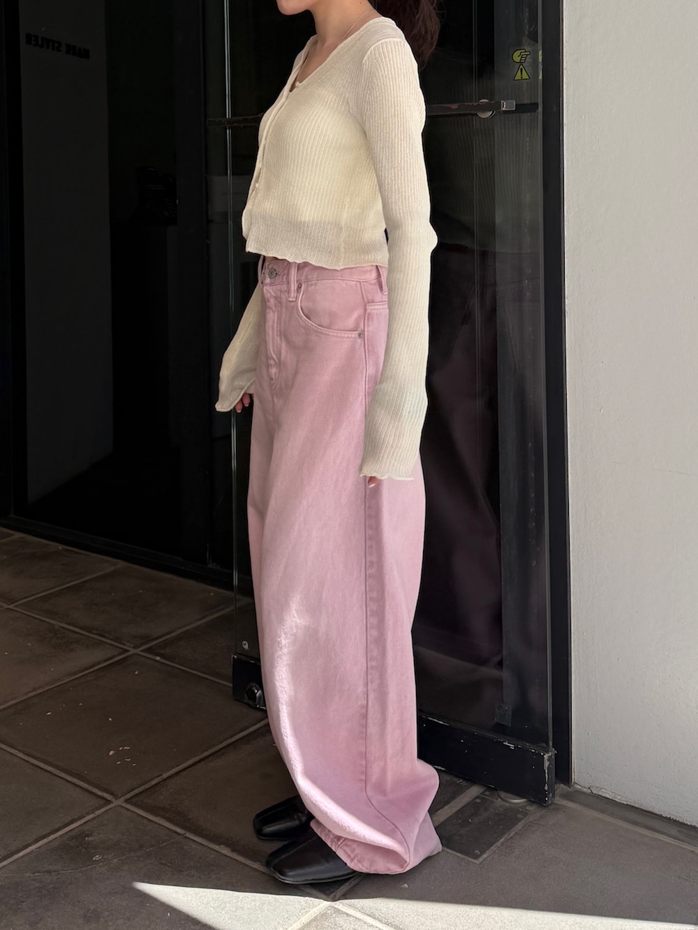 ピンク系のデニムパンツ、ブラック系のサンダル、ホワイト系のカーディガン/ボレロを着用したレディースの春コーディネートの6枚目の写真