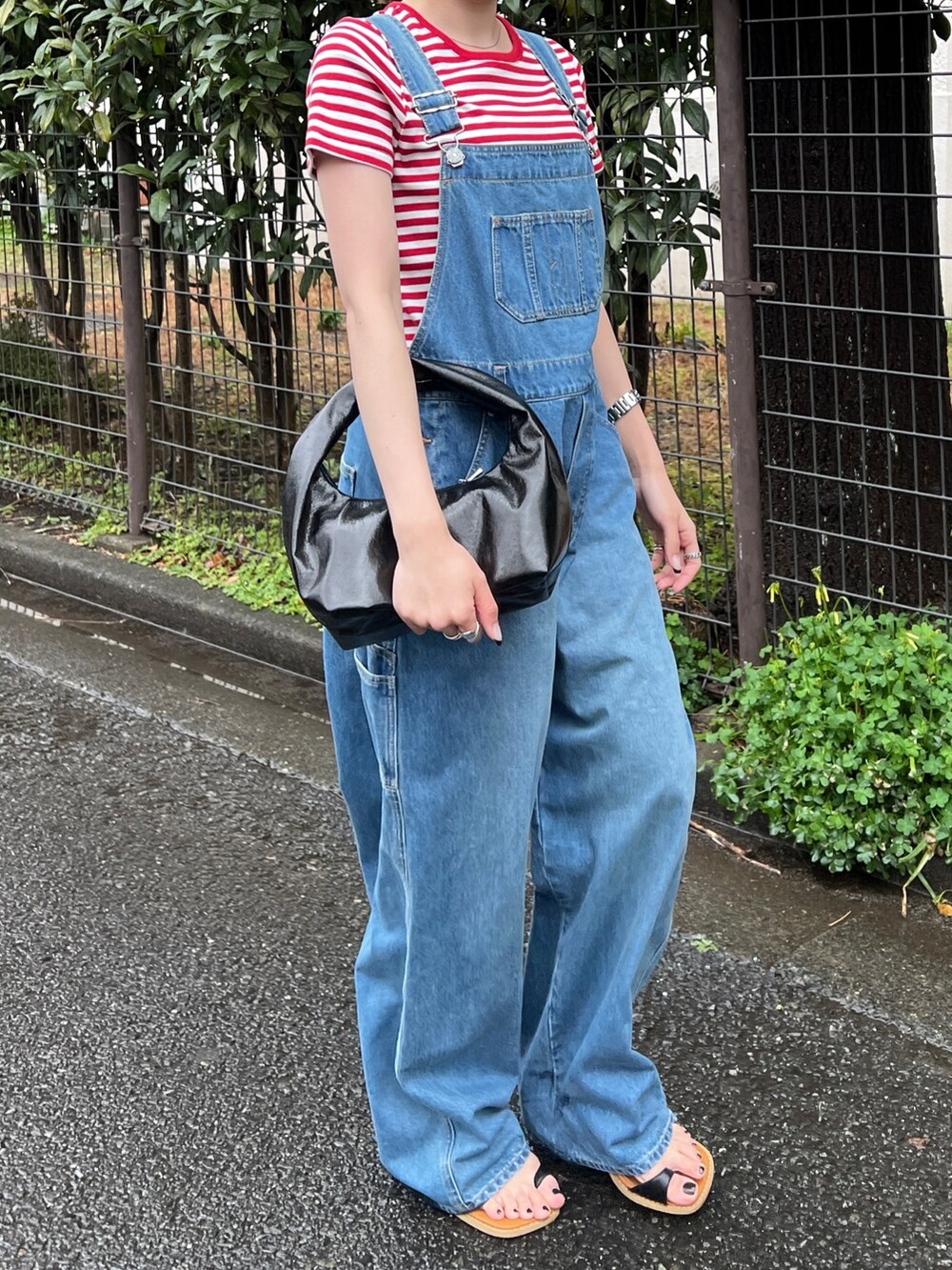 ブラック系のサンダル、ブルー系のつなぎ/オールインワン、レッド系のTシャツ/カットソーを着用したレディースの春コーディネートの6枚目の写真