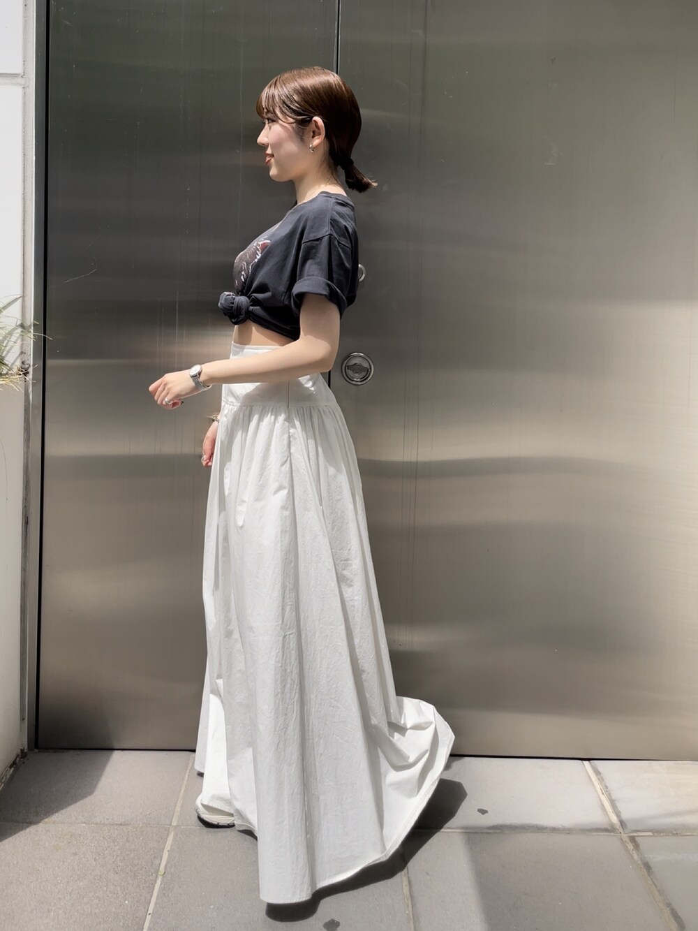 ホワイト系のスカート、グレー系のTシャツ/カットソー、ゴールド系のネックレスを着用したレディースの春コーディネートの8枚目の写真