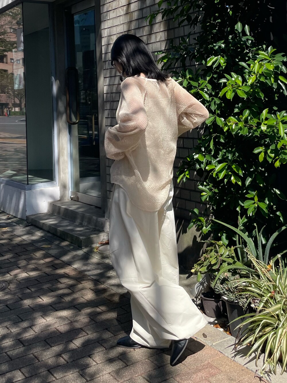 ブラック系のブーツ、ホワイト系のチノパンツ、ホワイト系のTシャツ/カットソーを着用したレディースの冬コーディネートの6枚目の写真