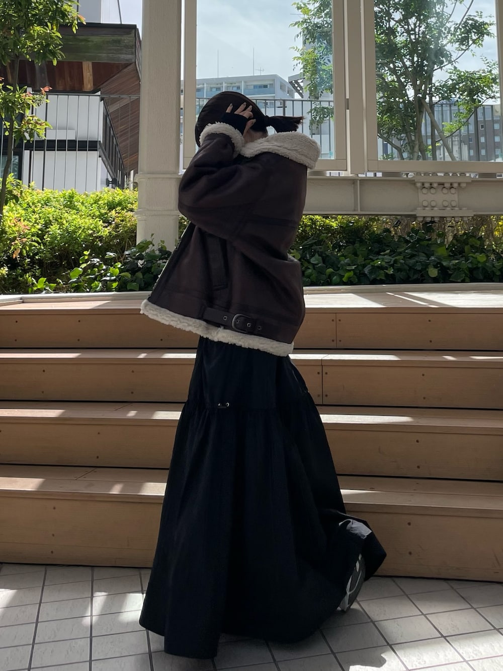 ブラック系のワンピース、ブラウン系のムートンコートを着用したレディースの秋コーディネートの6枚目の写真