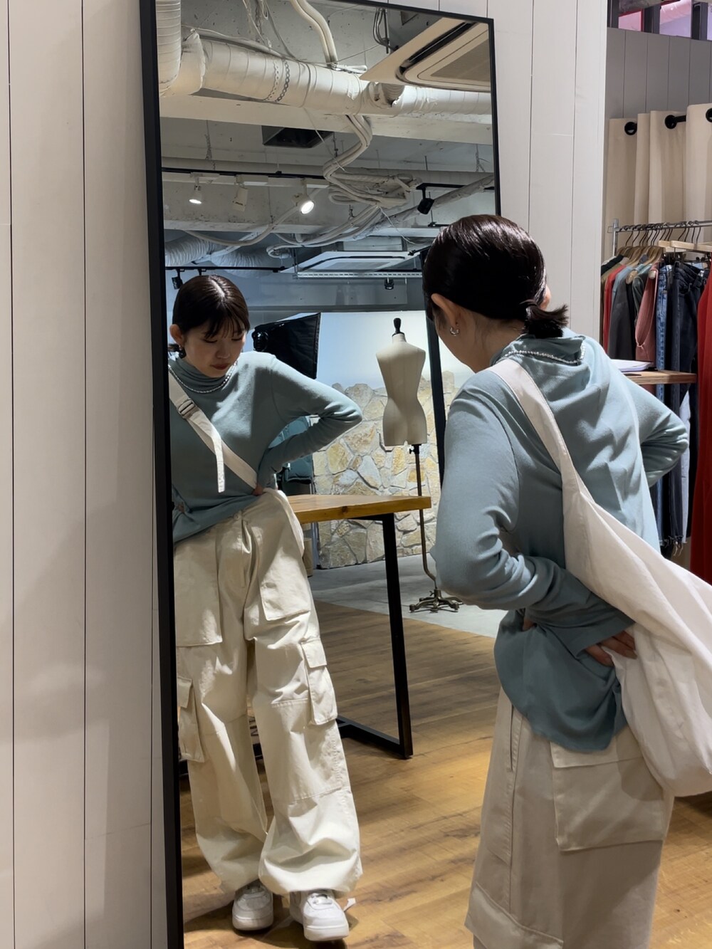 ホワイト系のカーゴパンツ、ホワイト系のショルダーバッグ、ブルー系のTシャツ/カットソーを着用したレディースの夏コーディネートの3枚目の写真