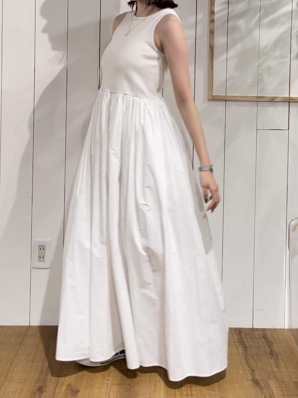 ホワイト系のワンピース、ゴールド系のネックレスを着用したレディースの夏コーディネートの3枚目の写真