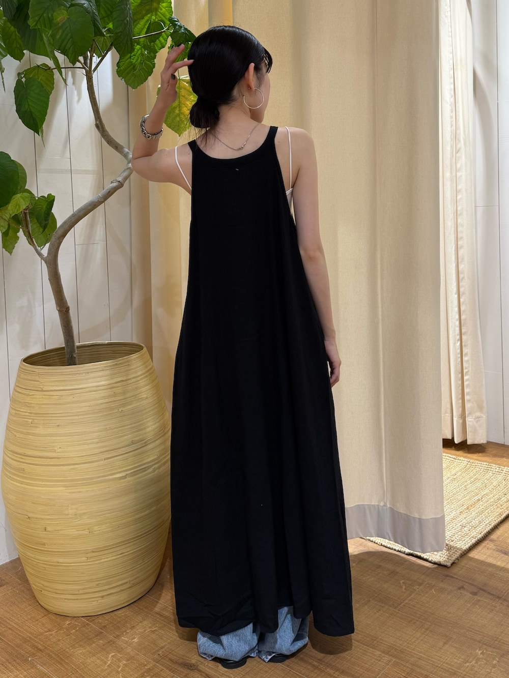 ブラック系のワンピース、ブルー系のデニムパンツ、ブラック系のサンダルを着用したレディースの夏コーディネートの3枚目の写真