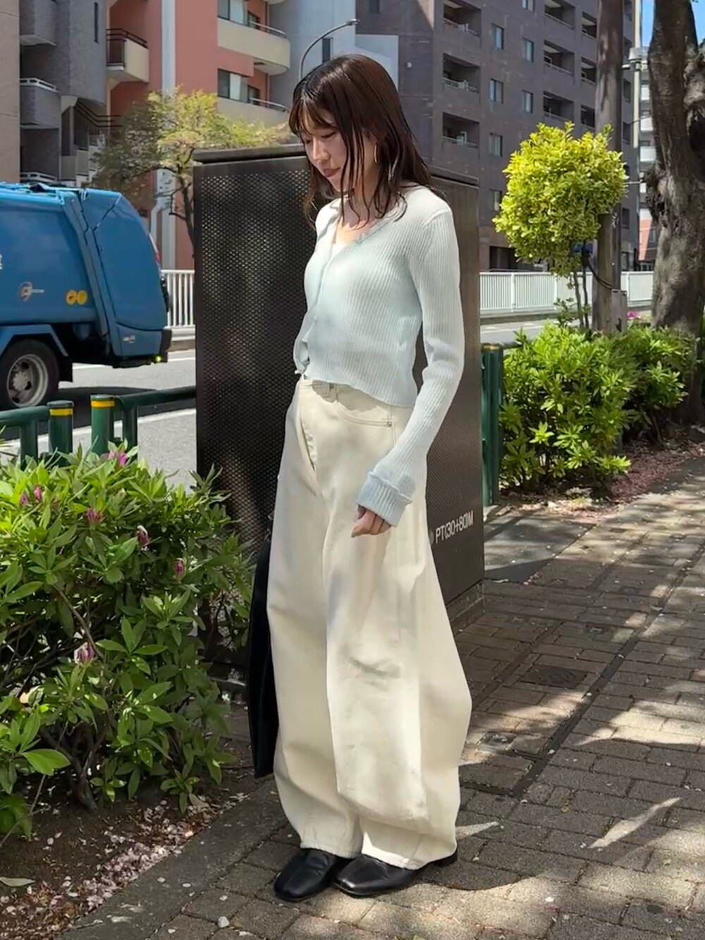 ブルー系のカーディガン/ボレロ、ホワイト系のデニムパンツ、ブラック系のハンドバッグを着用したレディースの春コーディネートの3枚目の写真
