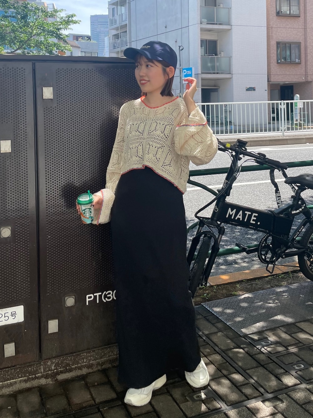 ブラック系のワンピース、ホワイト系のニット/セーター、ブルー系のキャップを着用したレディースの夏コーディネートの2枚目の写真