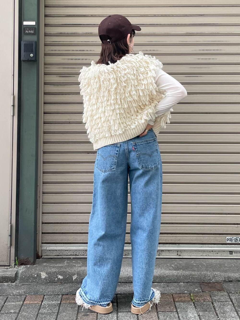 ホワイト系のサンダル、ブルー系のデニムパンツ、ホワイト系のベストを着用したレディースの夏コーディネートの3枚目の写真