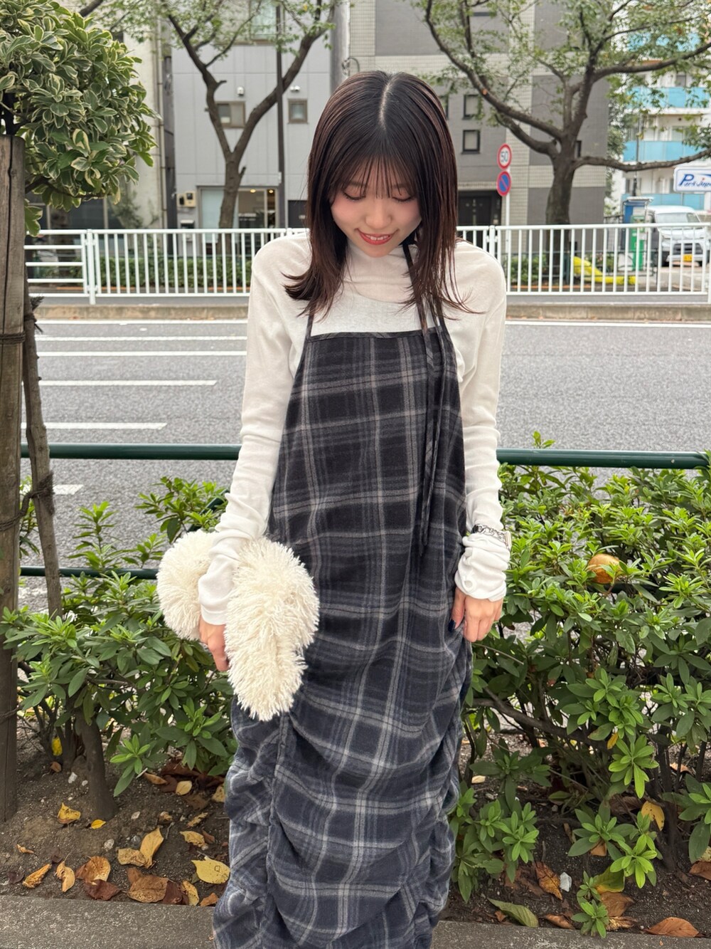 グレー系のワンピース、ホワイト系のハンドバッグ、ホワイト系のTシャツ/カットソーを着用したレディースの秋コーディネートの2枚目の写真