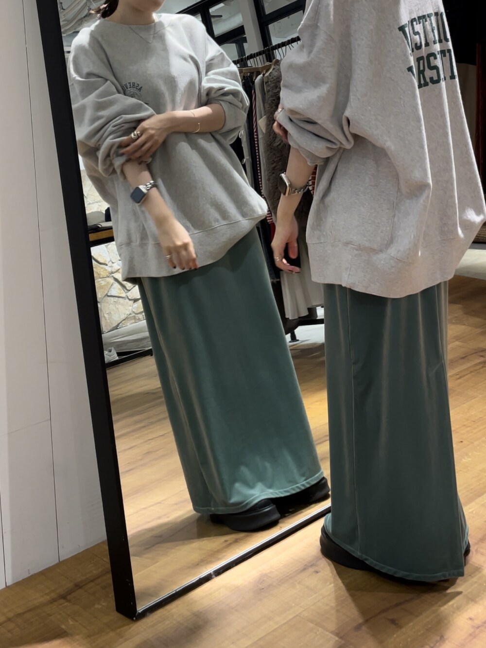 グリーン系のワンピース、ブラック系のブーツ、グレー系のスウェットを着用したレディースの秋コーディネートの3枚目の写真