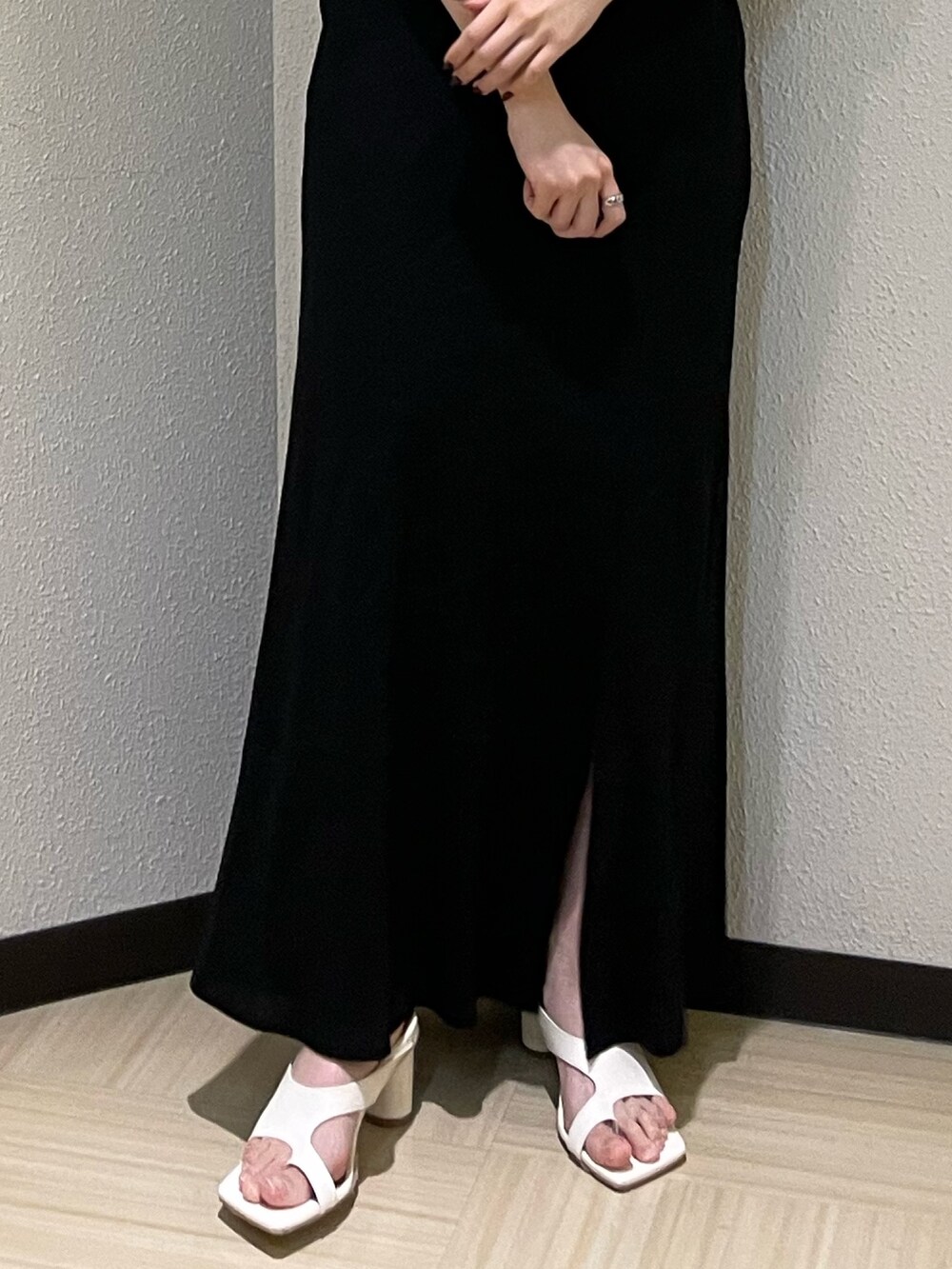 ホワイト系のサンダル、ベージュ系のTシャツ/カットソー、ブラック系のスカートを着用したレディースの春コーディネートの7枚目の写真