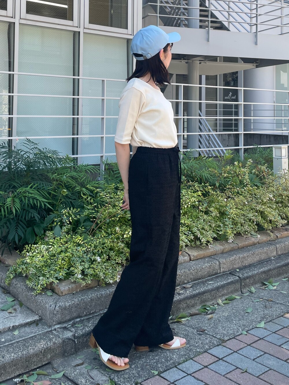ホワイト系のサンダル、ブラック系のその他パンツ、ホワイト系のTシャツ/カットソーを着用したレディースの夏コーディネートの7枚目の写真