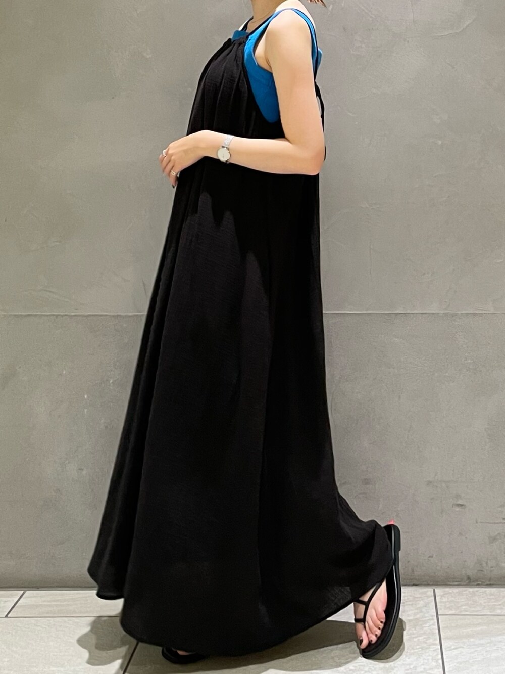 ブルー系のタンクトップ、ブラック系のワンピース、ブラック系のサンダルを着用したレディースの夏コーディネートの4枚目の写真