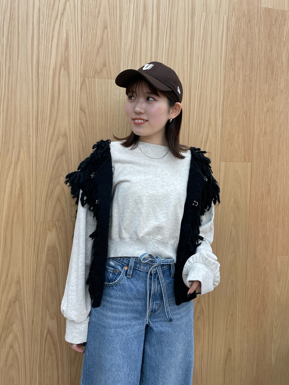 ブルー系のデニムパンツ、ブラック系のブーツ、グレー系のスウェットを着用したレディースの秋コーディネートの7枚目の写真