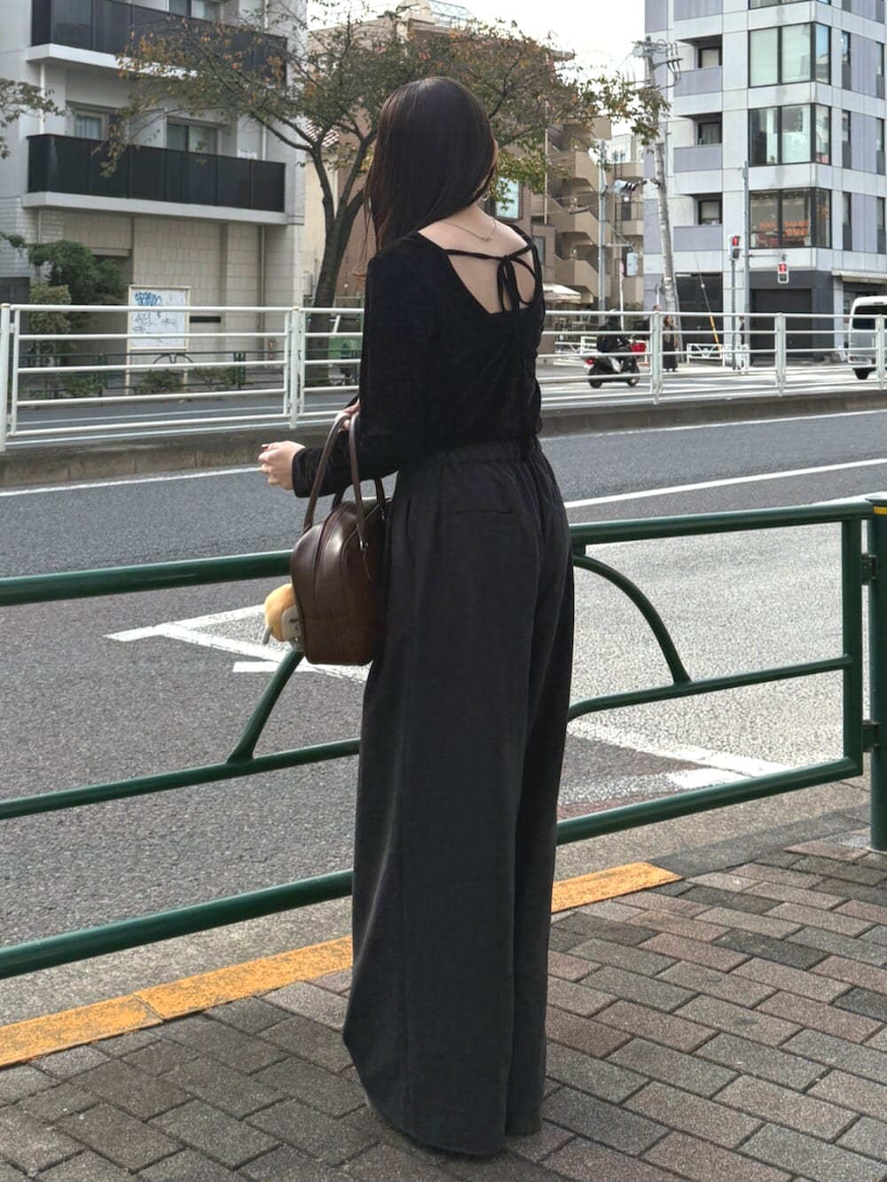 ブラウン系のハンドバッグ、グレー系のその他パンツ、ブラック系のTシャツ/カットソーを着用したレディースの秋コーディネートの2枚目の写真