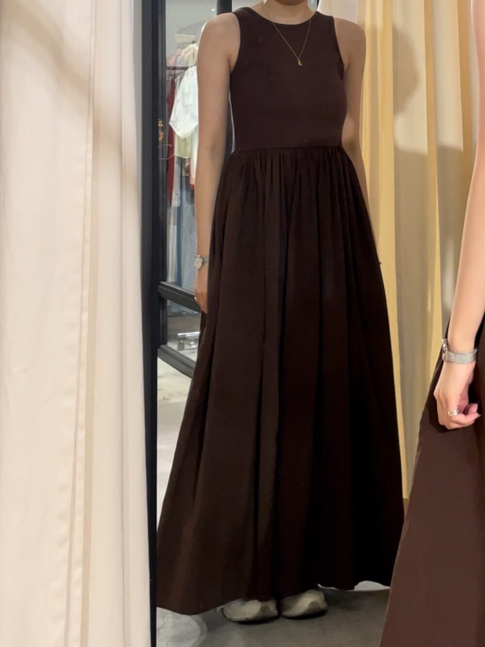 ホワイト系のキャミソール、ブラウン系のワンピース、ゴールド系のネックレスを着用したレディースの春コーディネートの7枚目の写真