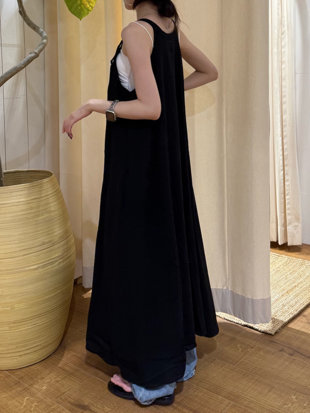 ブラック系のワンピース、ブルー系のデニムパンツ、ブラック系のサンダルを着用したレディースの夏コーディネートの4枚目の写真