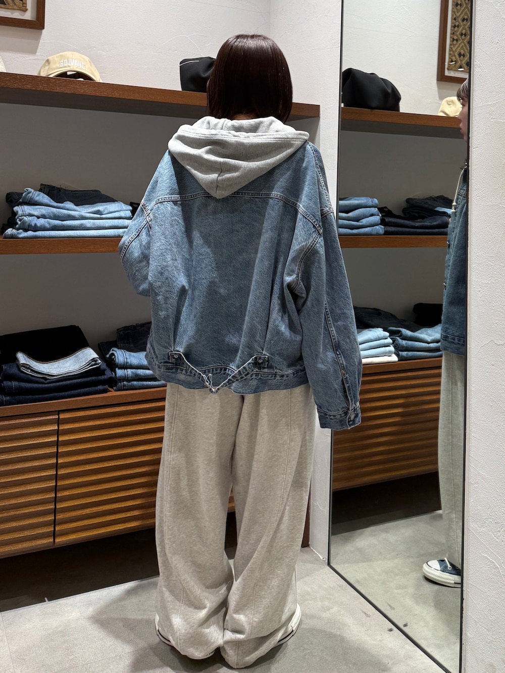 ホワイト系のスウェットパンツ、ブルー系のスニーカー、ブルー系のデニムジャケットを着用したレディースの春コーディネートの3枚目の写真