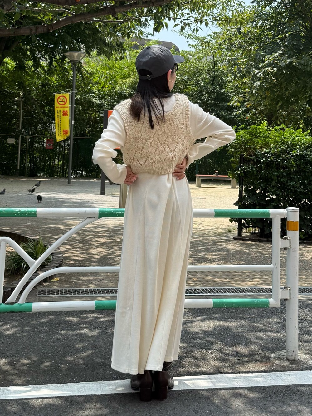 ホワイト系のワンピース、ブラウン系のブーツ、グレー系のキャップを着用したレディースの秋コーディネートの2枚目の写真