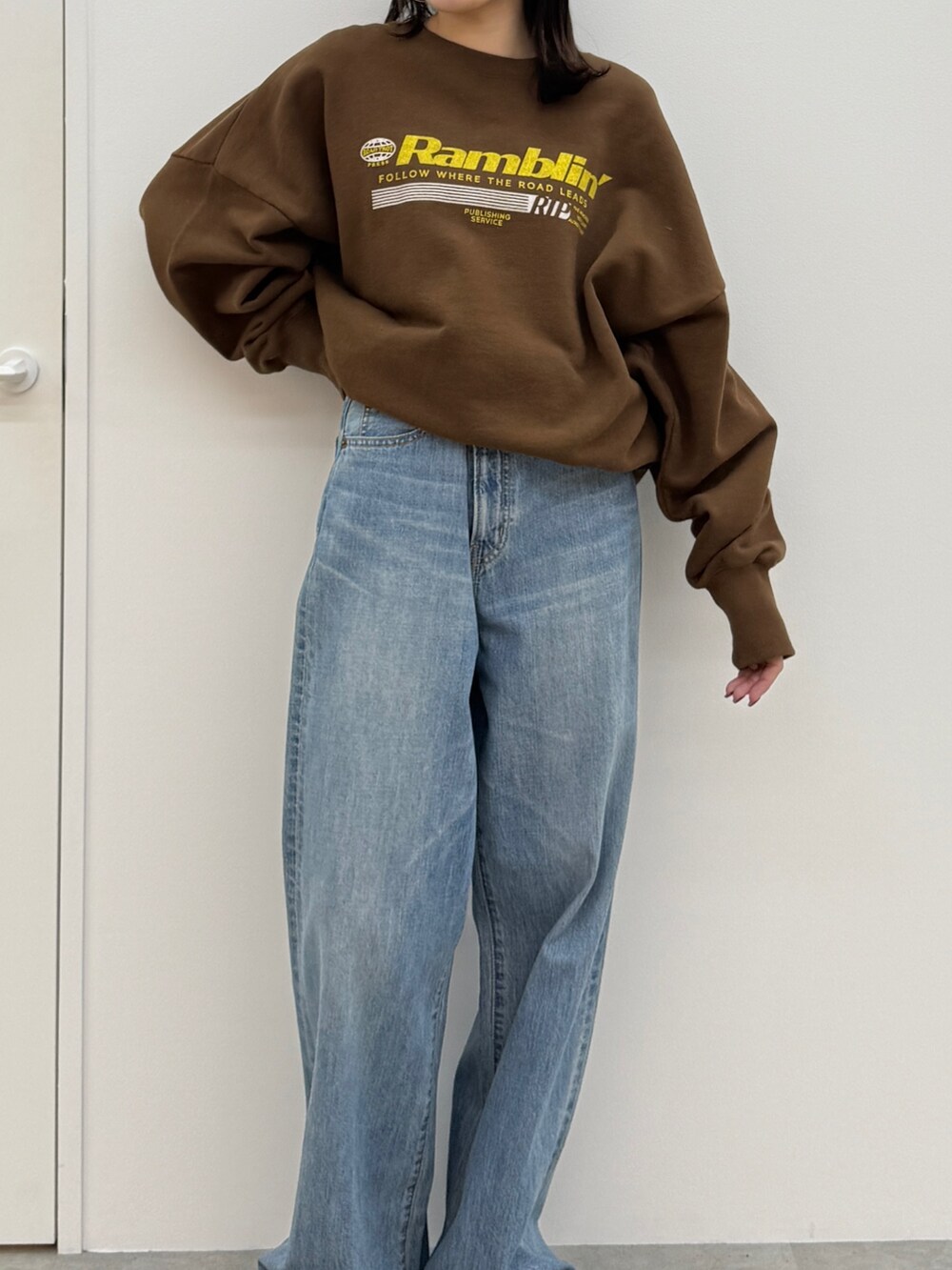ブルー系のデニムパンツ、ブラック系のブーツ、ブラウン系のスウェットを着用したレディースの秋コーディネートの5枚目の写真