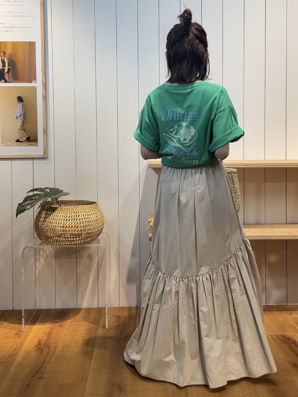 グリーン系のTシャツ/カットソー、ホワイト系のスカート、ベージュ系のかごバッグを着用したレディースの夏コーディネートの2枚目の写真