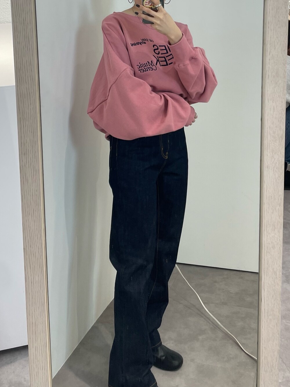 ブラック系のブーツ、ピンク系のスウェット、ブルー系のデニムパンツを着用したレディースの冬コーディネートの7枚目の写真