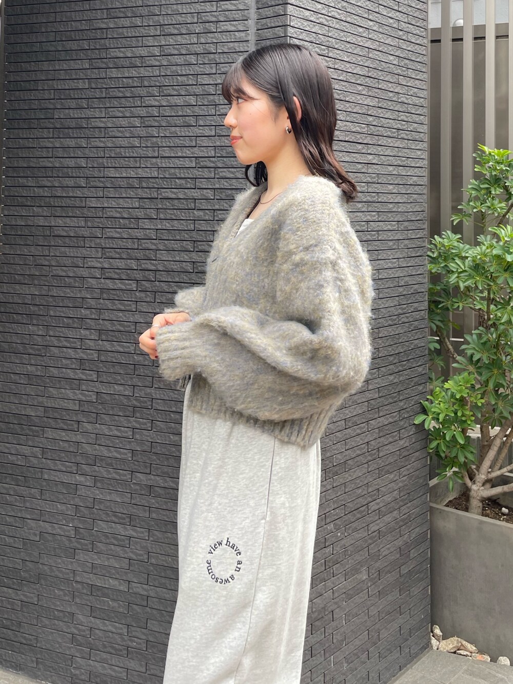 グレー系のスウェットパンツ、ブラック系のブーツ、グレー系のカーディガン/ボレロを着用したレディースの冬コーディネートの2枚目の写真