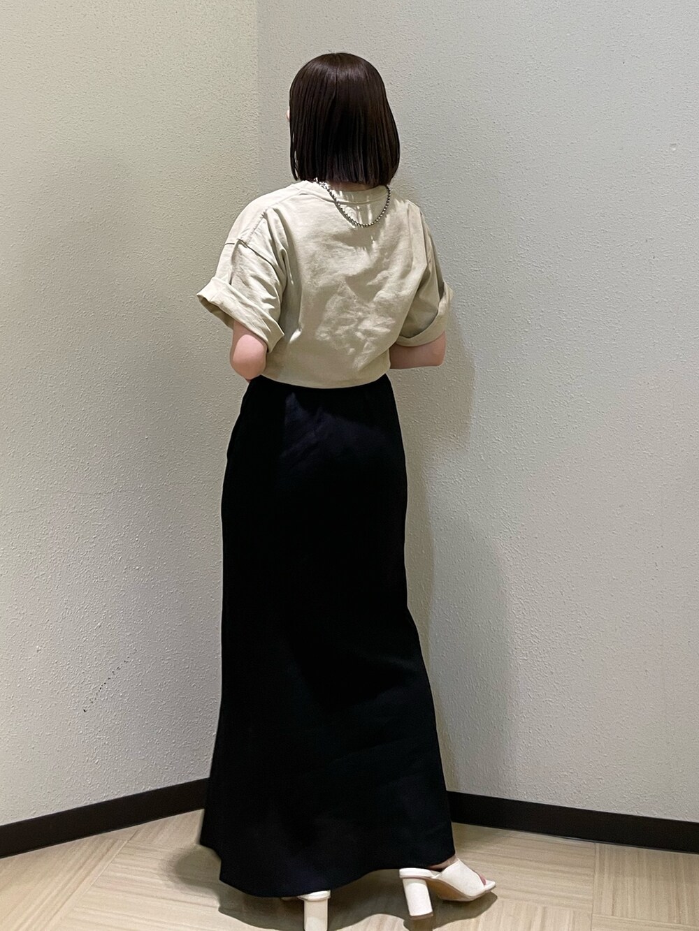ホワイト系のサンダル、ベージュ系のTシャツ/カットソー、ブラック系のスカートを着用したレディースの春コーディネートの4枚目の写真