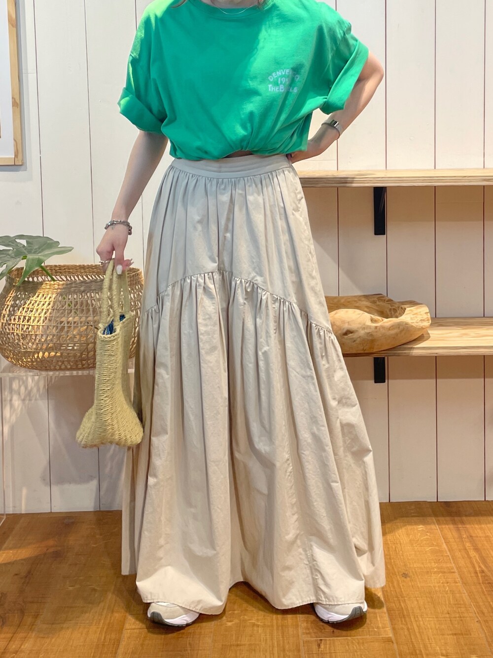 グリーン系のTシャツ/カットソー、ホワイト系のスカート、ベージュ系のかごバッグを着用したレディースの夏コーディネートの6枚目の写真