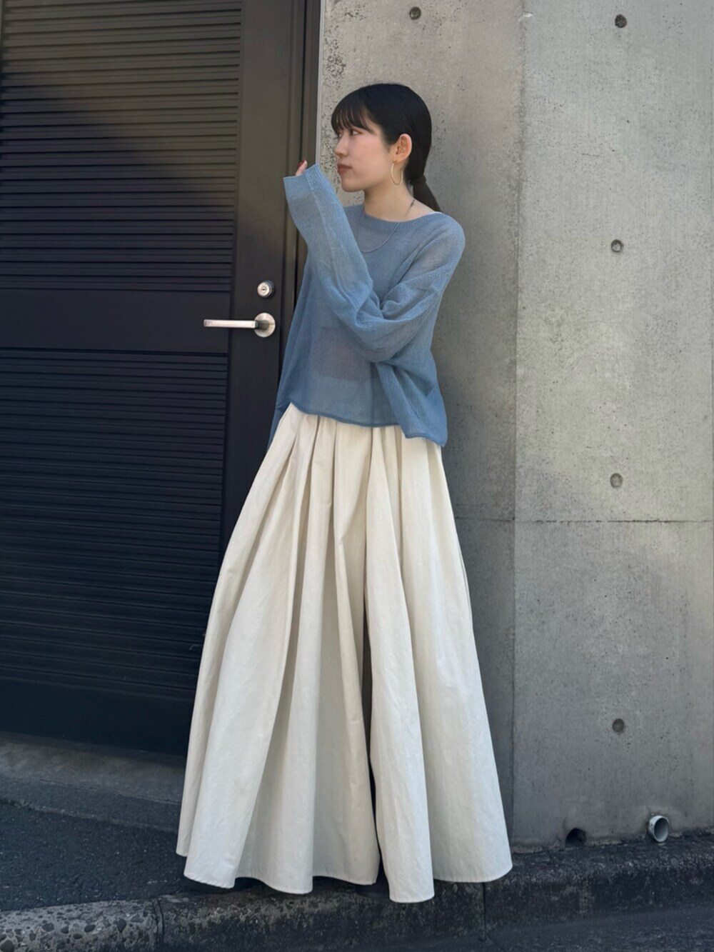 ホワイト系のスカート、ブラウン系のブーツ、ブルー系のニット/セーターを着用したレディースの秋コーディネートの2枚目の写真