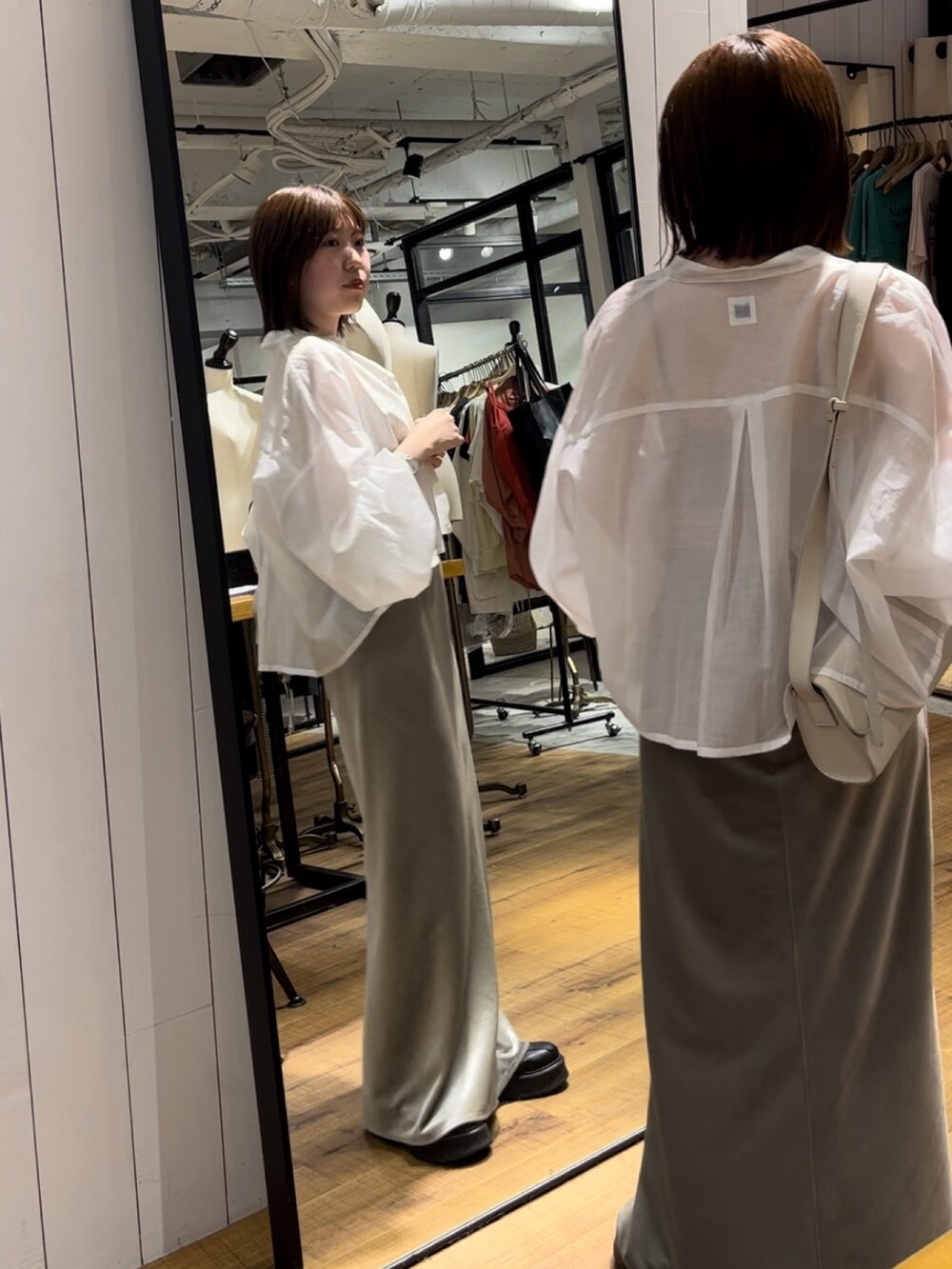 ベージュ系のキャミソール、グレー系のスカート、ブラック系のブーツを着用したレディースの夏コーディネートの3枚目の写真