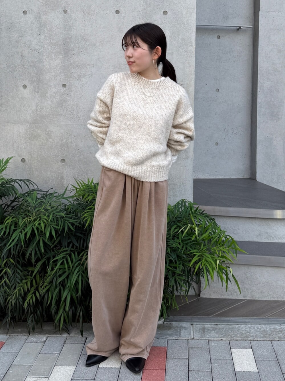 ベージュ系のスウェットパンツ、ブラック系のブーツ、ホワイト系のTシャツ/カットソーを着用したレディースの秋コーディネートの2枚目の写真