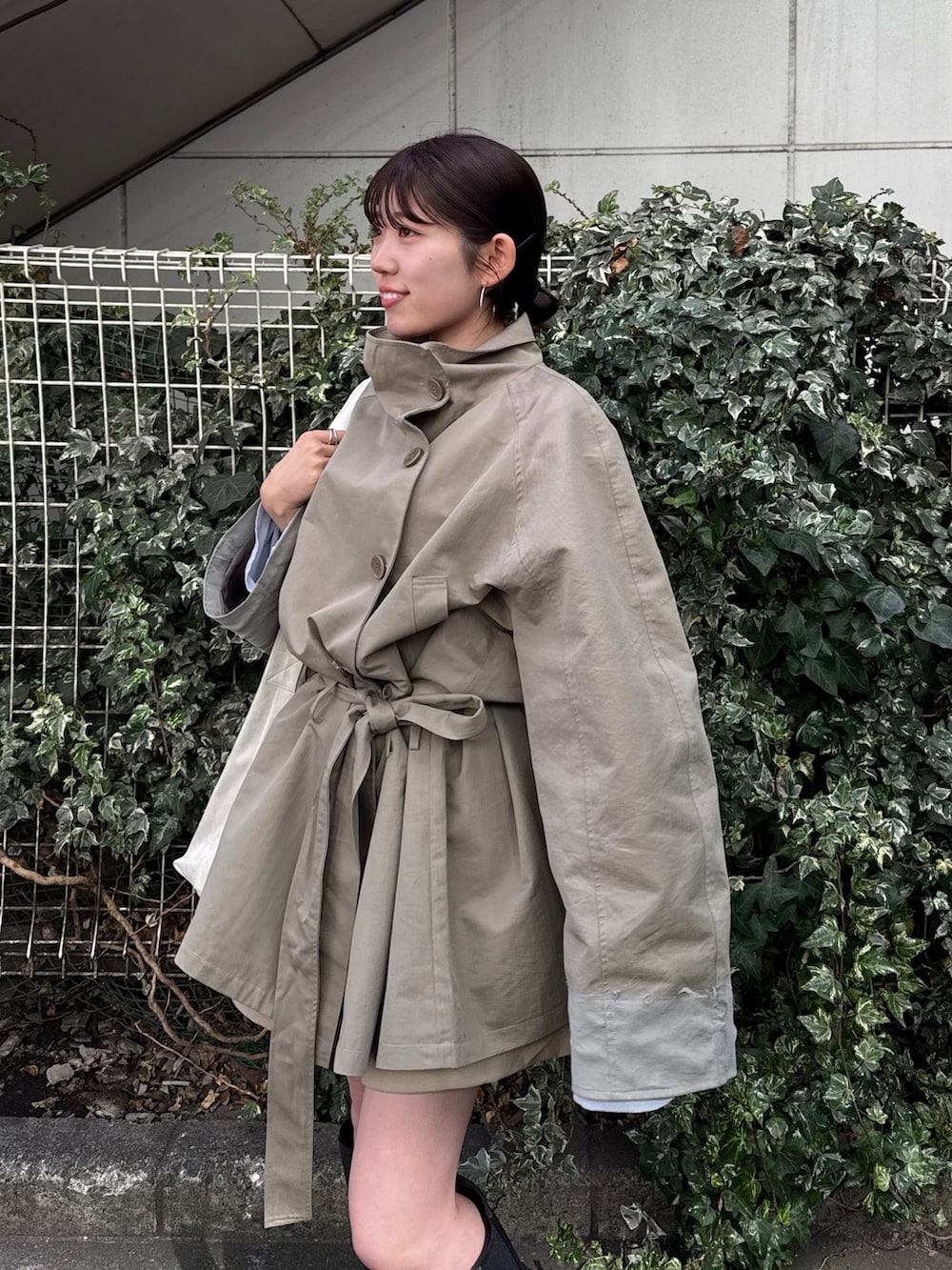 グリーン系のトレンチコート、ベージュ系のその他パンツを着用したレディースの冬コーディネートの7枚目の写真