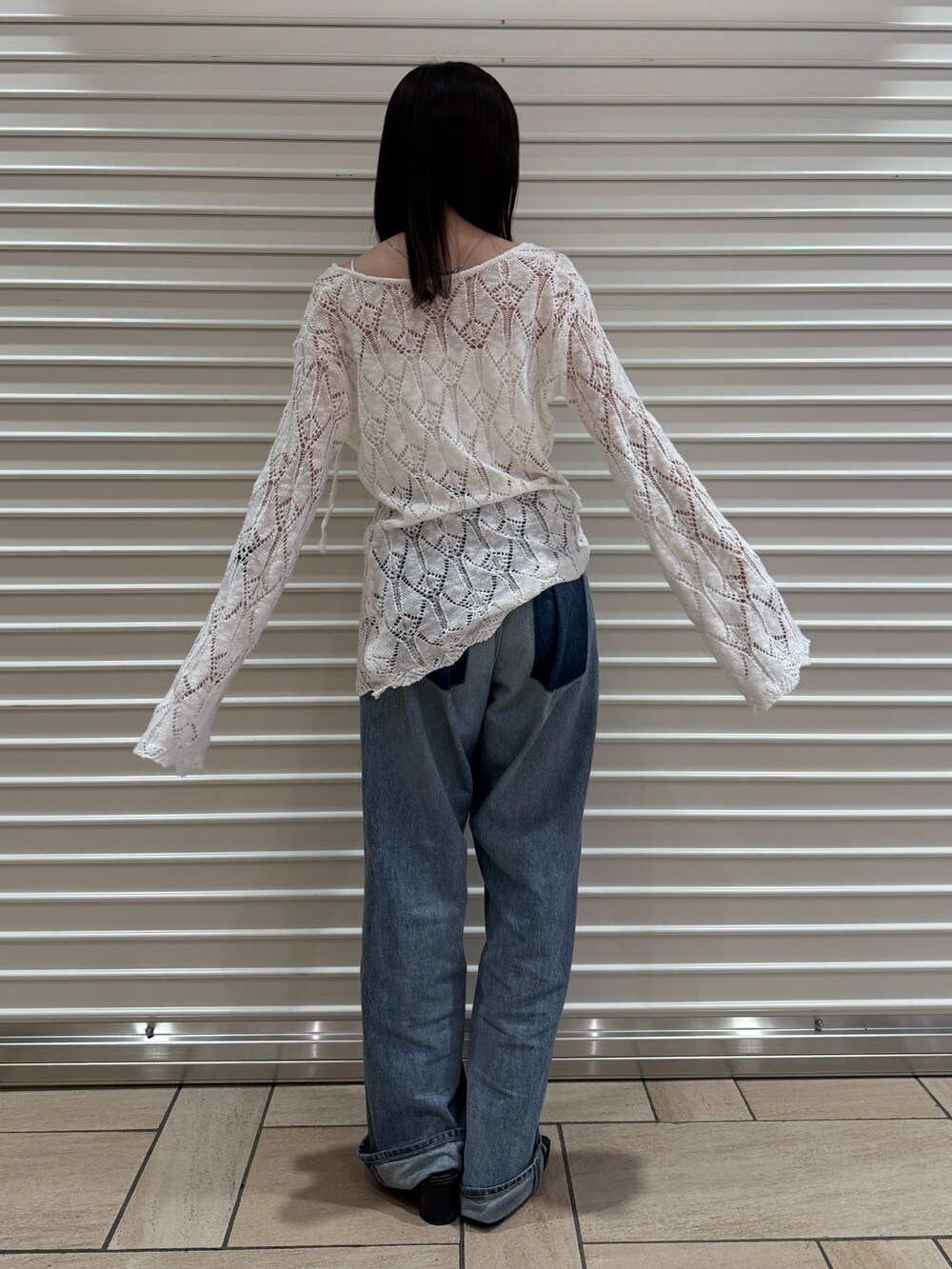 ブルー系のデニムパンツ、ホワイト系のニット/セーターを着用したレディースの夏コーディネートの2枚目の写真