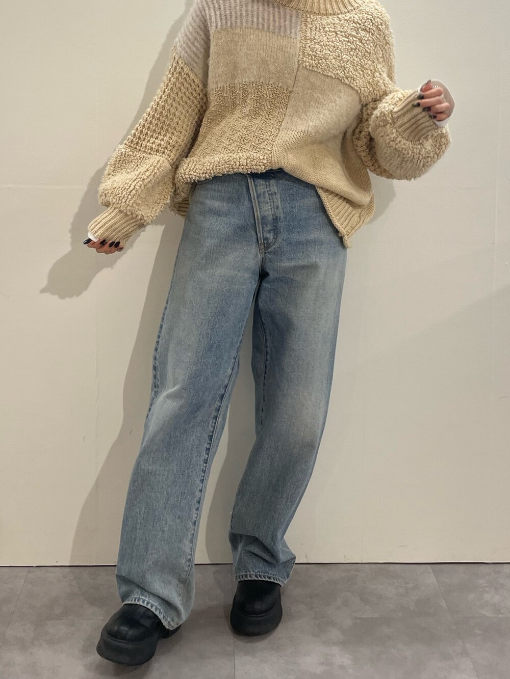 ホワイト系のTシャツ/カットソー、ブルー系のデニムパンツ、ブラック系のブーツを着用したレディースの冬コーディネートの4枚目の写真