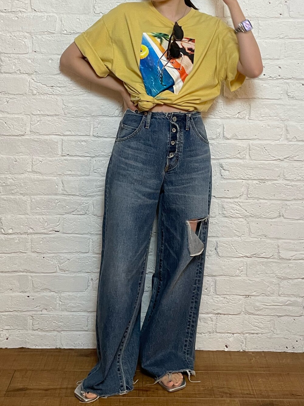 シルバー系のサンダル、ブルー系のデニムパンツ、イエロー系のTシャツ/カットソーを着用したレディースの夏コーディネートの7枚目の写真