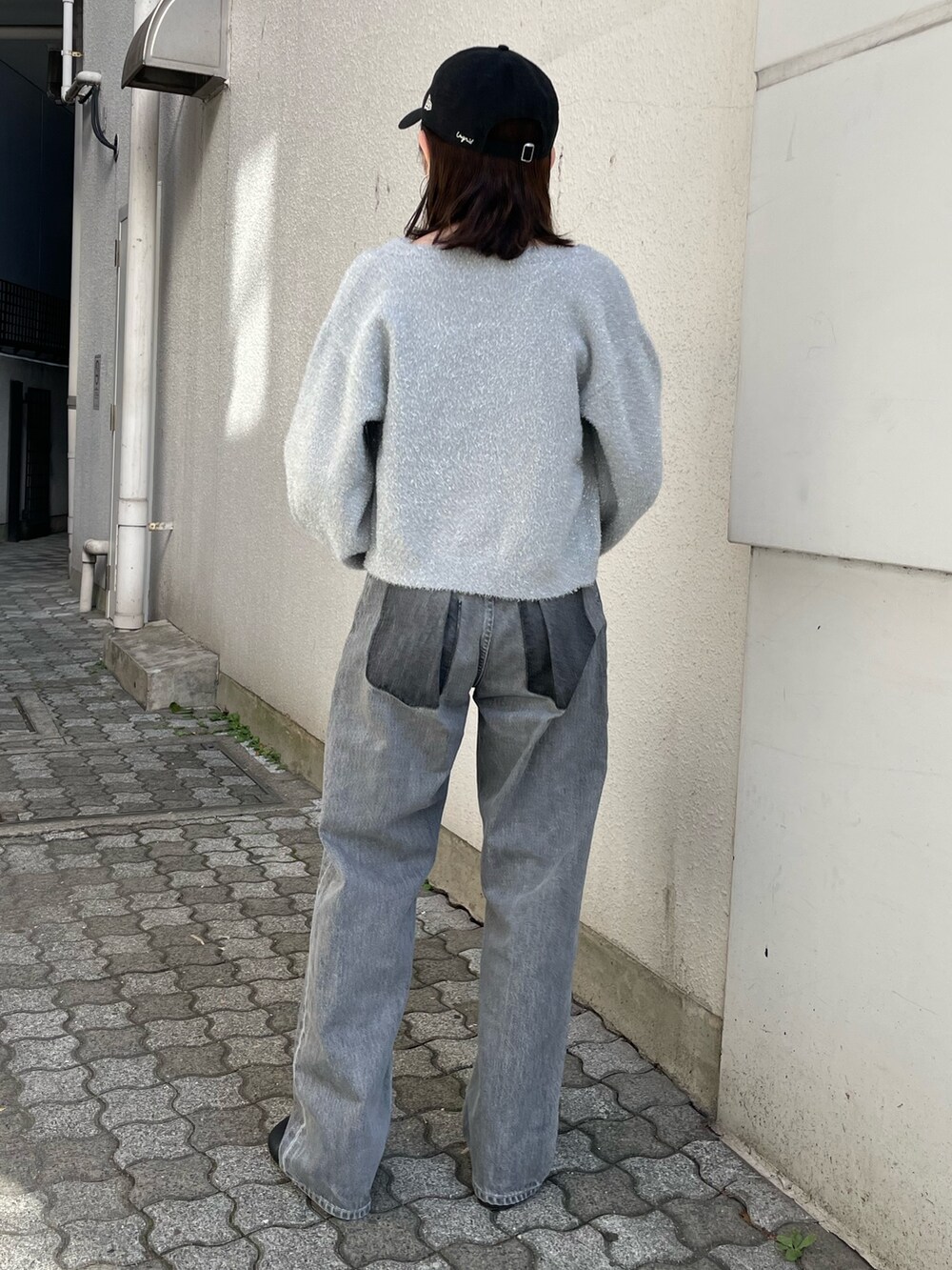 ブラック系のショルダーバッグ、ブラック系のブーツ、ブラック系のデニムパンツを着用したレディースの冬コーディネートの6枚目の写真